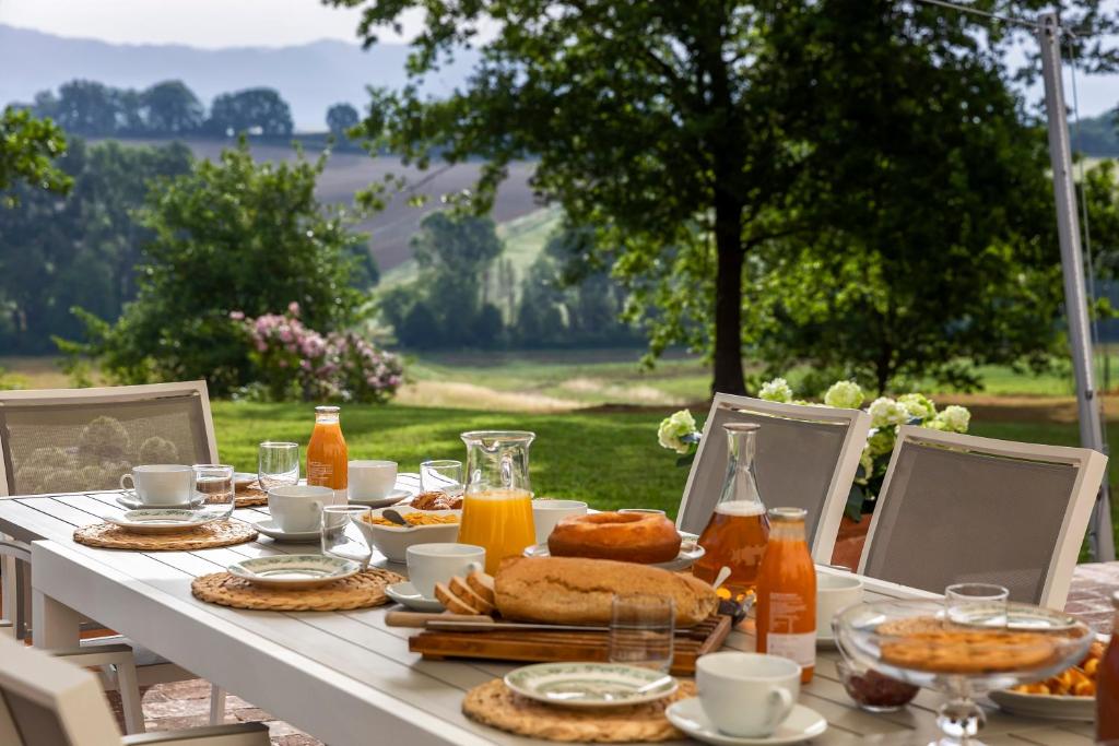 une table avec un petit-déjeuner composé de pain et de jus d'orange dans l'établissement Villa Colonica Tuori at Tenuta Schifanoia, à San Piero a Sieve