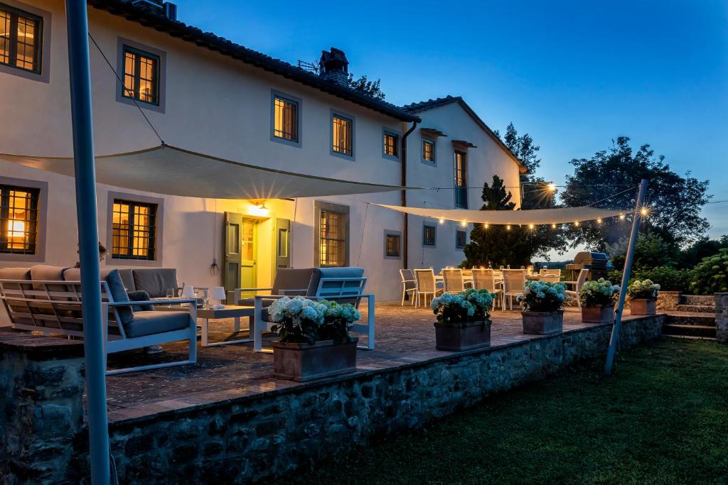 une maison avec une terrasse extérieure la nuit dans l'établissement Villa Colonica Tuori at Tenuta Schifanoia, à San Piero a Sieve
