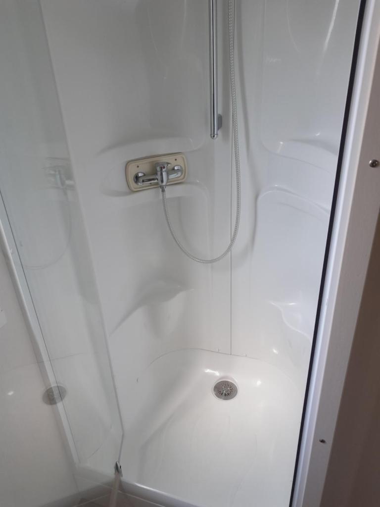 une cabine de douche avec un pommeau et un lavabo dans l'établissement Grand mobilhome spacieux 8 places frejus/straphael, à Fréjus