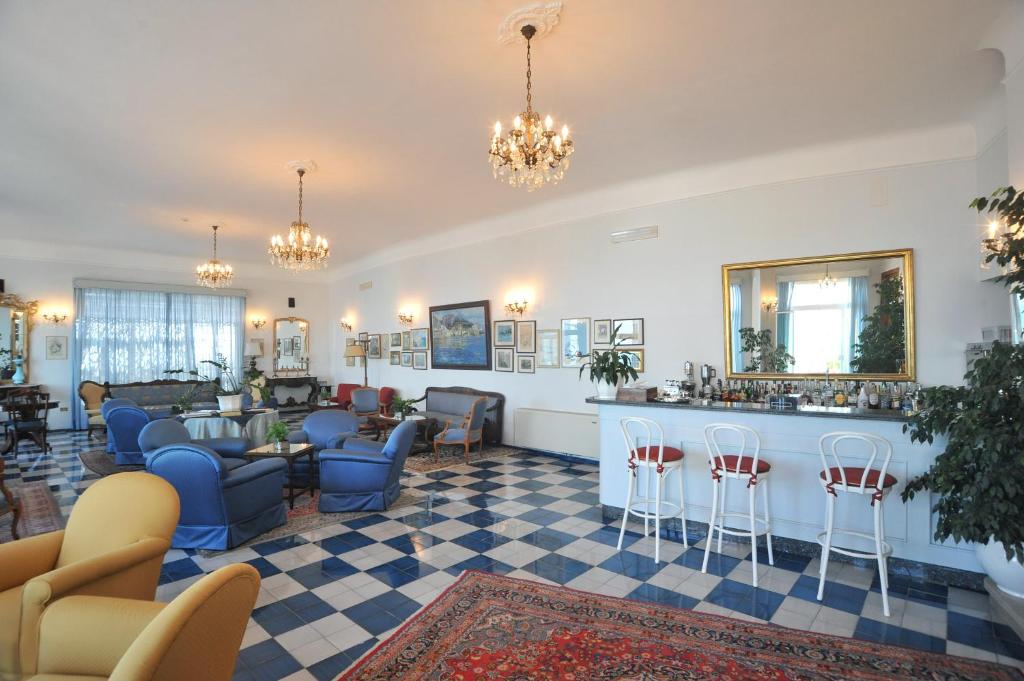 un hall d'entrée avec une salle d'attente avec des chaises et un bar dans l'établissement Hotel Belvedere, à Conca dei Marini
