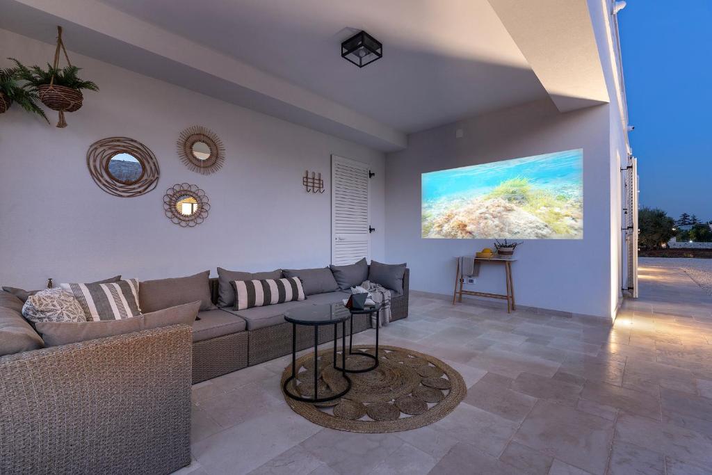 un salon avec un canapé et un tableau au mur dans l'établissement Vilaa Isa Beautiful Villa and trullo in Ostuni, à Ostuni
