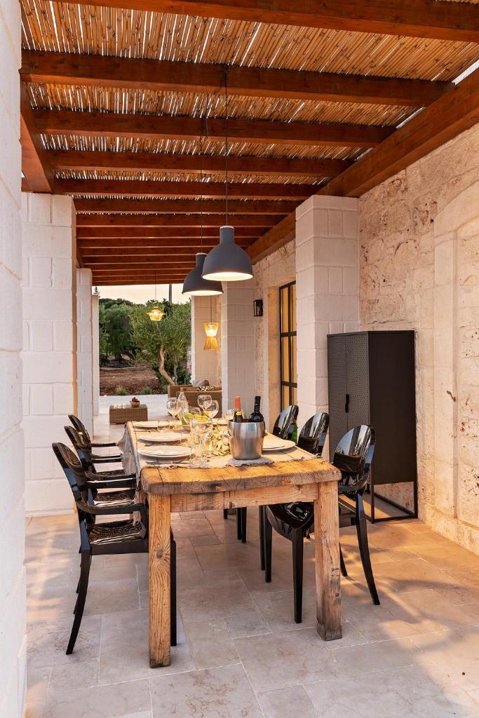 une salle à manger avec une table et des chaises en bois dans l'établissement Vilaa Isa Beautiful Villa and trullo in Ostuni, à Ostuni