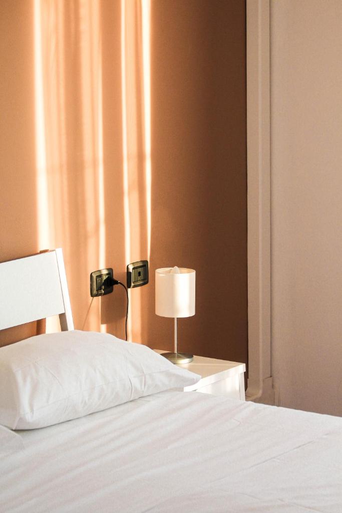 une chambre avec un lit et une lampe sur une table dans l'établissement Hotel Fontaine Bleue, à Orta San Giulio