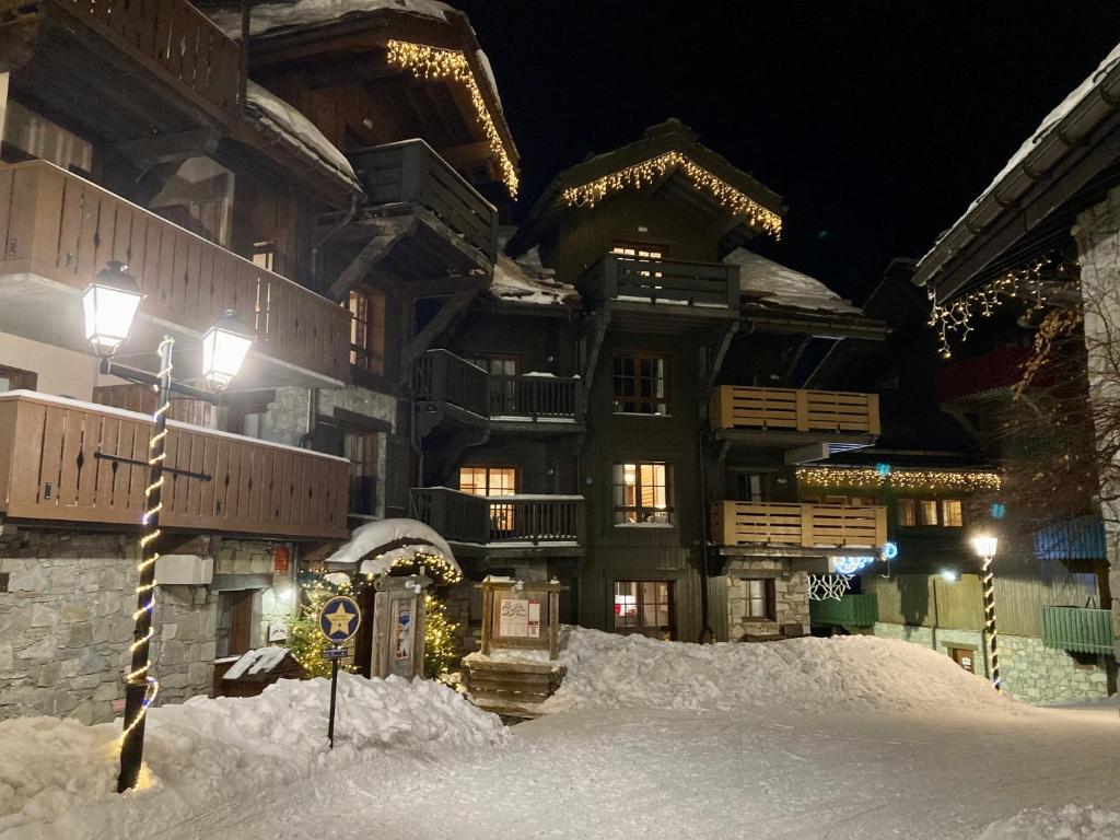 un bâtiment avec de la neige devant lui la nuit dans l'établissement Appartement ARC 1950 m, Ski au pied, piscine extérieure chauffée, remontées mécaniques à 100m, sauna et salle de sports, à Arc 1950