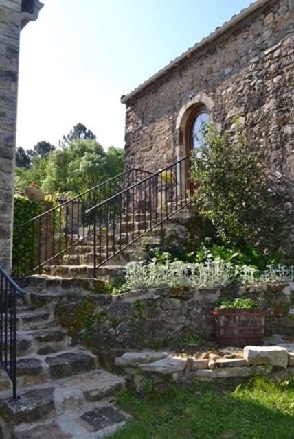 un ancien bâtiment en pierre avec des escaliers et une clôture dans l'établissement Gite rural au calme en Cévennes Gardoises, à Saint-Jean-du-Gard