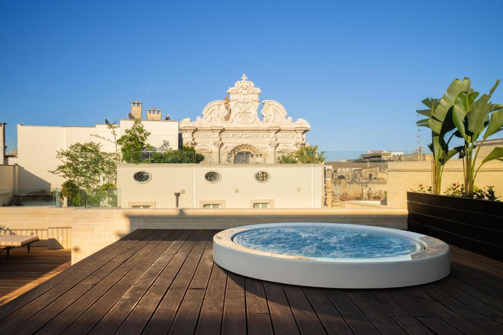 un jacuzzi sur une terrasse avec un bâtiment en arrière-plan dans l'établissement Patria Palace Lecce - The Leading Hotels of The World, à Lecce