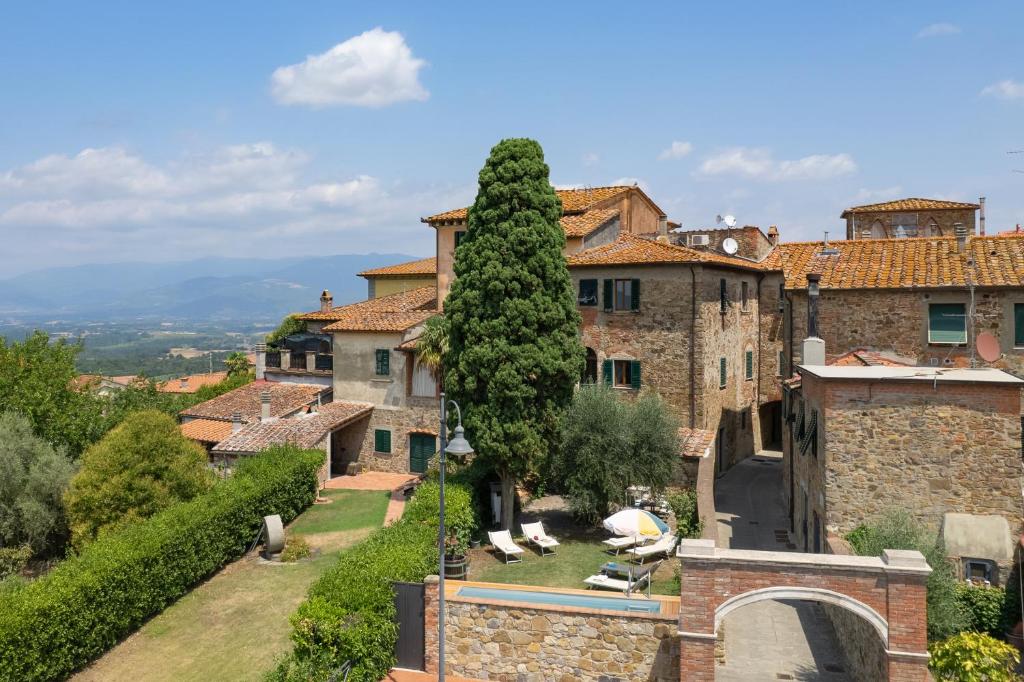 un grand bâtiment avec un arbre devant dans l'établissement Villa Fracassini, à Pergine Valdarno