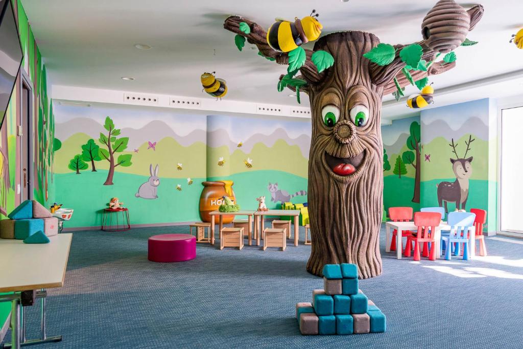 - une salle de jeux pour enfants avec un arbre au milieu dans l'établissement Blu Suite Resort, à Bellaria-Igea Marina
