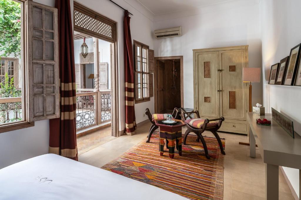 une chambre avec un lit, une table et des chaises dans l'établissement Riad Altair, à Marrakech 37 autres photos