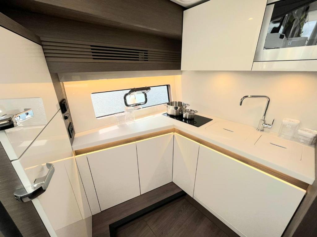 une cuisine avec des armoires blanches et un évier dans l'établissement Puissance, Elegance et Style, Yacht à Deauville, à Deauville