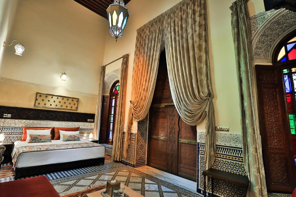 - une chambre avec un lit et une porte en bois dans l'établissement Riad Moulaydriss et Giacomo, à Fès