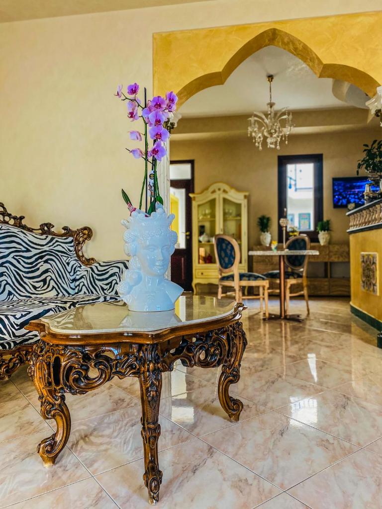 un vase avec des fleurs sur une table dans une pièce dans l'établissement Araba Fenice Hotel, à San Vito Lo Capo