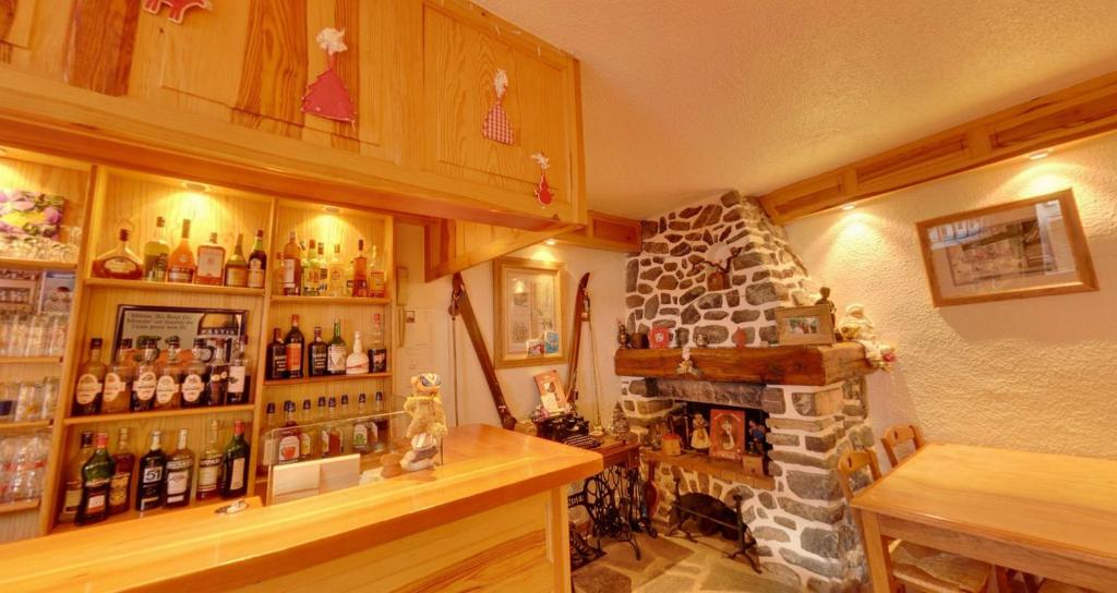 Cette chambre comprend une cheminée et une étagère avec des bouteilles. dans l'établissement Hôtel Le Lievre Blanc, à Vars