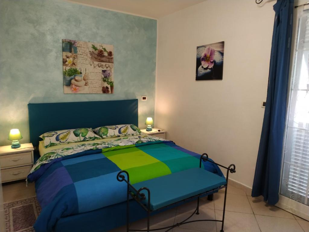 une chambre avec un lit avec une couette colorée dans l'établissement VILLA PANORAMICA & IDROMASSAGGIO 008031-LT-0055, à Imperia