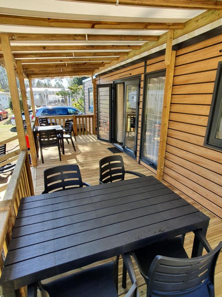 une terrasse en bois avec une table et des chaises dessus dans l'établissement Bahiana, à Saint-Julien-en-Born