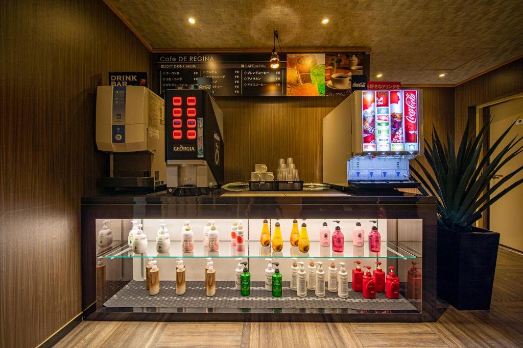 une vitrine dans un restaurant avec un bouquet de boissons dans l'établissement ホテル継kei男塾ホテルグループ, à Himeji