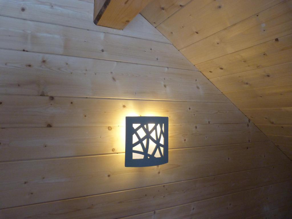 une lumière dans une pièce dotée de boiseries dans l'établissement Gite du Brin d'Herbe, à Pontarlier 14 autres photos