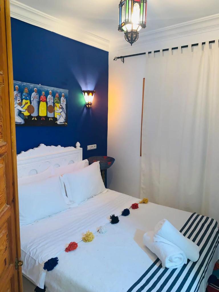 une chambre avec un lit blanc avec des fleurs dessus dans l'établissement Riad Les Miroirs, à Marrakech