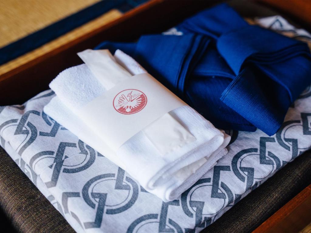 une boîte avec des serviettes blanches et un ruban bleu dans l'établissement Oogute Kohan Shirasagi So, à Shimojo mura
