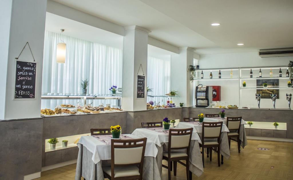 une salle à manger avec des tables et des chaises ainsi qu'une boulangerie dans l'établissement Hotel Sandra, à Rimini