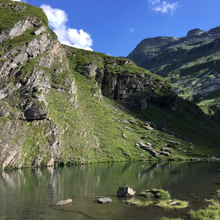 une montagne avec une masse d'eau devant elle dans l'établissement Ski Piau engaly 50 m des pistes de ski et du cœur de station, à Aragnouet