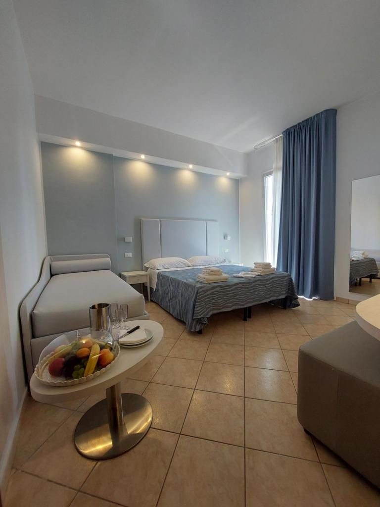 une chambre avec deux lits et une table avec des fruits dessus dans l'établissement Hotel Caravel Park, à Rimini