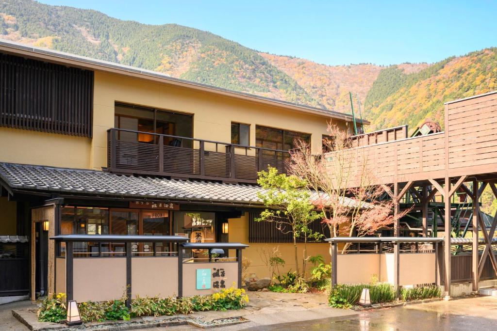 un bâtiment avec un balcon et des montagnes en arrière-plan dans l'établissement Iya Onsen, à Miyoshi
