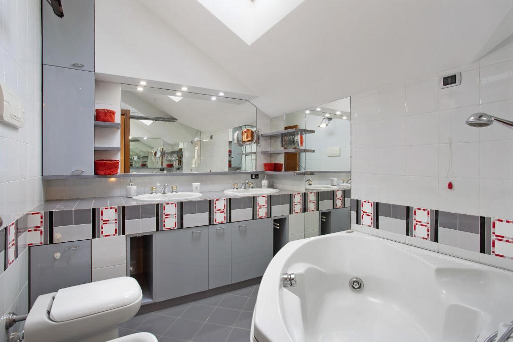 La salle de bains est pourvue d'une baignoire, de deux lavabos et de toilettes. dans l'établissement Villa La Palmetta, à Peschiera Borromeo