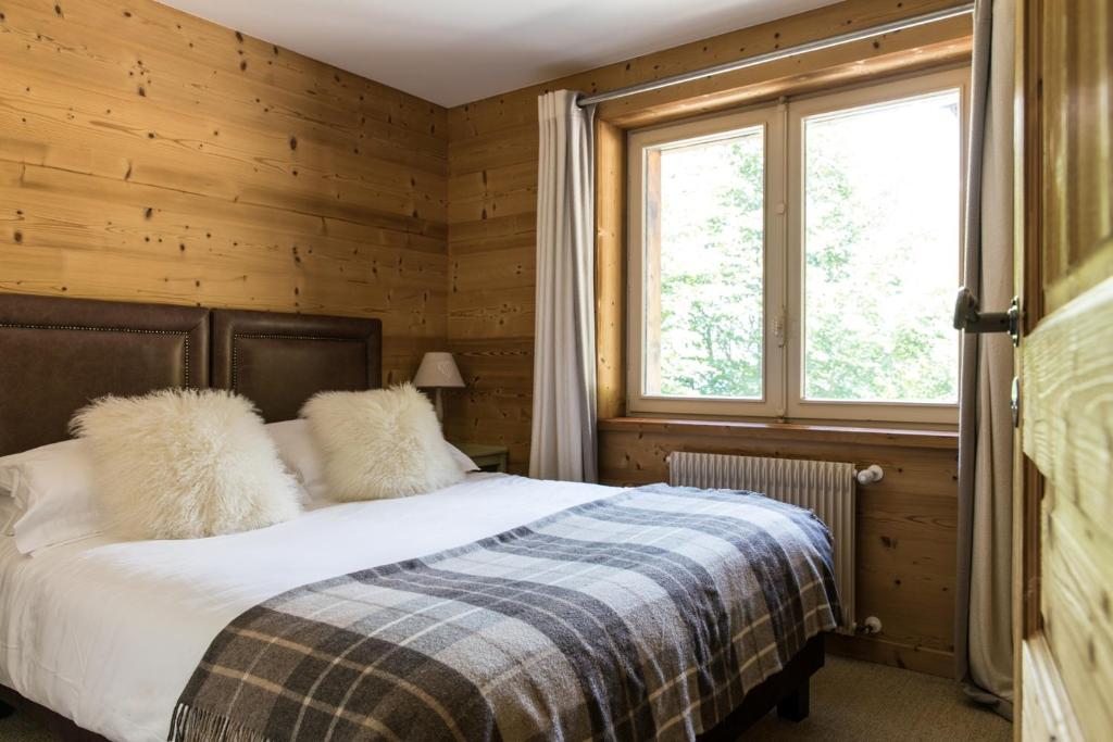 une chambre avec un lit et une fenêtre dans l'établissement Chalet Pres des Cimes ski-in ski-out, aux Houches