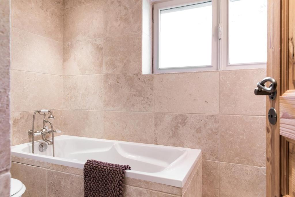 La salle de bains est pourvue d'une baignoire et d'une fenêtre. dans l'établissement Chalet Pres des Cimes ski-in ski-out, aux Houches 27 autres photos