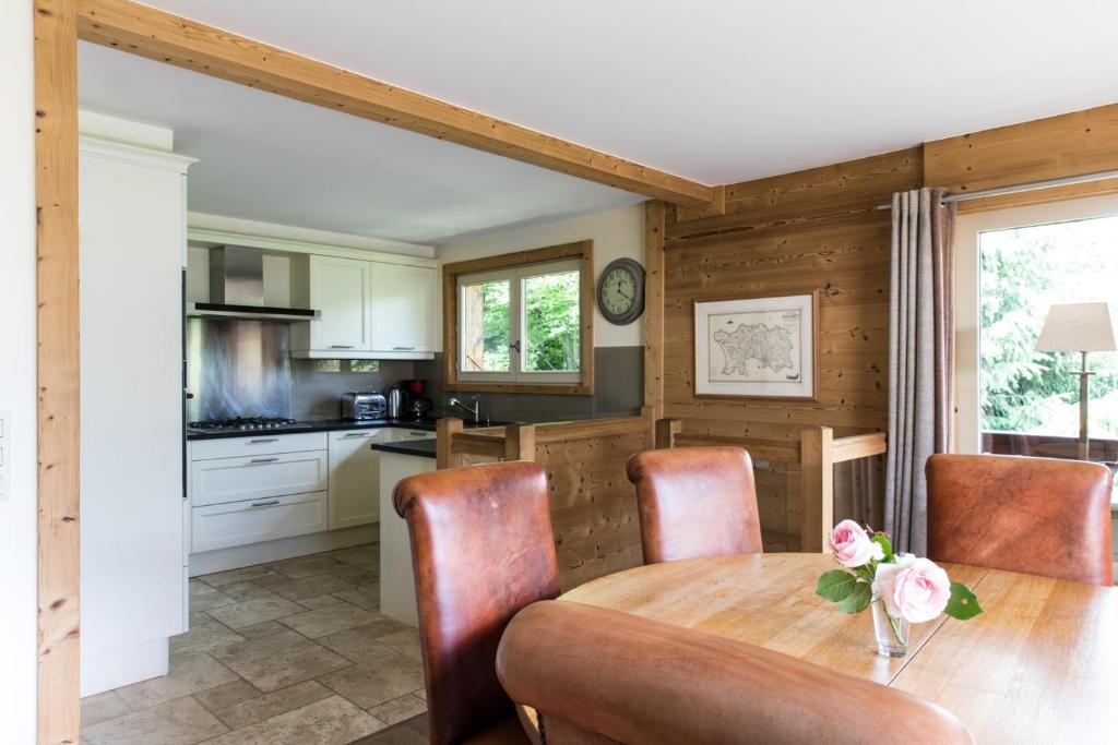 une cuisine et une salle à manger avec une table et des chaises dans l'établissement Chalet Pres des Cimes ski-in ski-out, aux Houches
