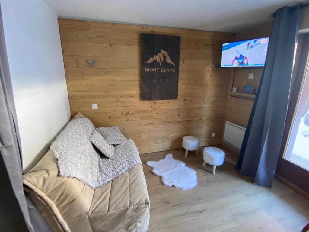 une chambre avec un lit et une télévision à écran plat dans l'établissement Chaleureux appartement rénové ambiance chalet, à Praz-sur-Arly