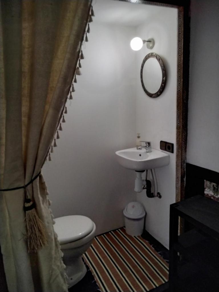 une salle de bain avec un lavabo, des toilettes et un miroir dans l'établissement Riad Bouchouari 33, à Marrakech