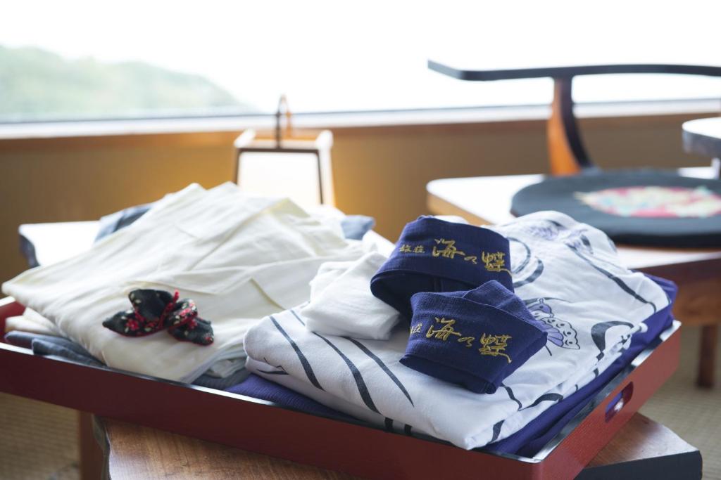 une pile de serviettes et de chaussures assises sur une table dans l'établissement Ryoso Uminocho, à Ise