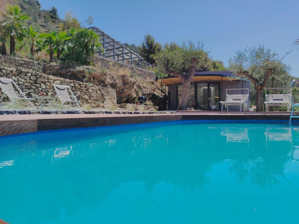 une piscine avec de l'eau bleue devant une maison dans l'établissement Villa Villa Vasca by Interhome, à Civezza
