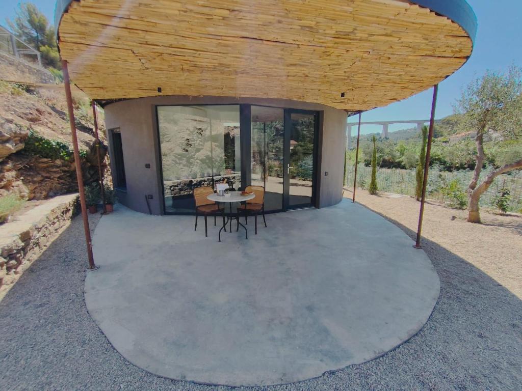 Cette petite maison dispose d'une terrasse ronde avec une table et des chaises. dans l'établissement Villa Villa Vasca by Interhome, à Civezza