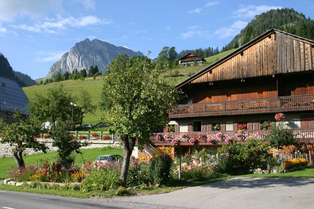 un bâtiment avec des fleurs devant lui dans l'établissement Terra-Beka Lodge, à La Chapelle-dʼAbondance