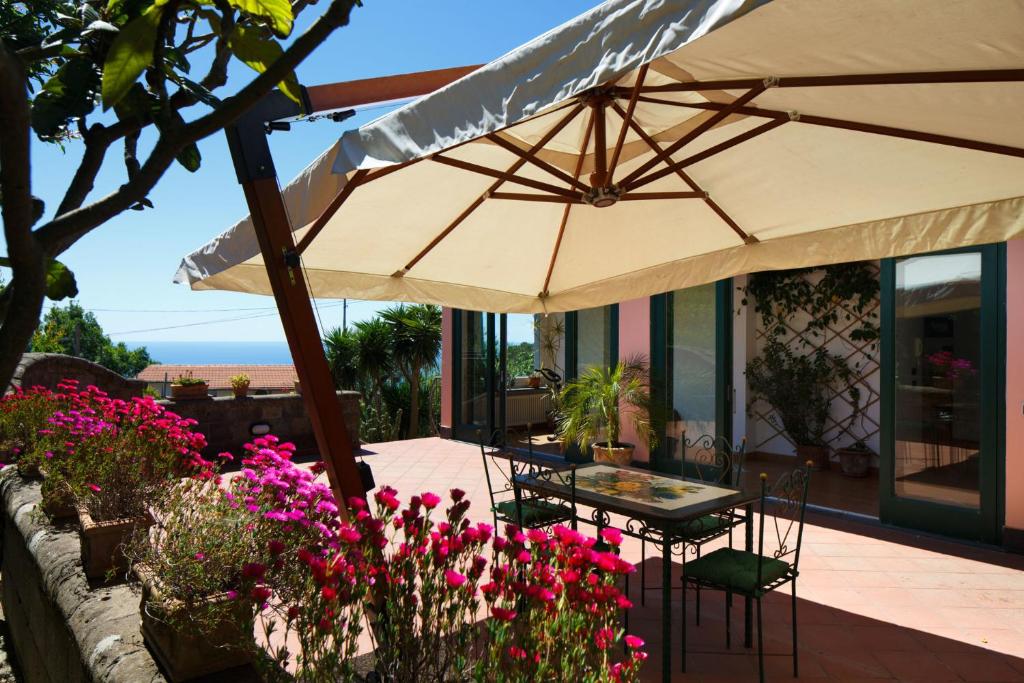 un patio avec une table et un parasol dans l'établissement Villa Eugenia, à Sant'Agnello