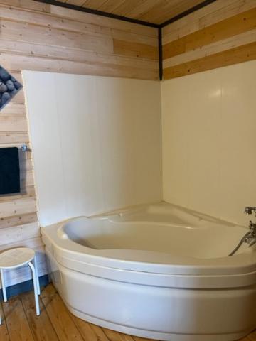 - une baignoire blanche dans une chambre avec tabouret dans l'établissement Chalet 8-10 personnes sur la station des Rousses, à Lamoura