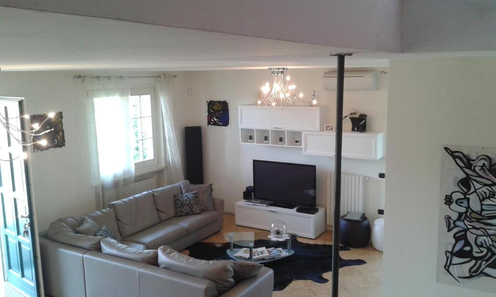 un salon avec un canapé et une télévision dans l'établissement Villa Elisa Relax, à Pozzolengo