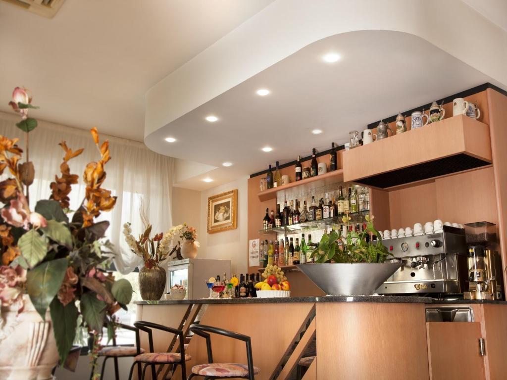 une cuisine avec un comptoir avec des tabourets et un bar dans l'établissement Hotel Atlantic, à Bellaria-Igea Marina