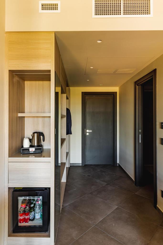un couloir d'une cuisine avec un réfrigérateur et une porte dans l'établissement Salina Hotel, à Tarente