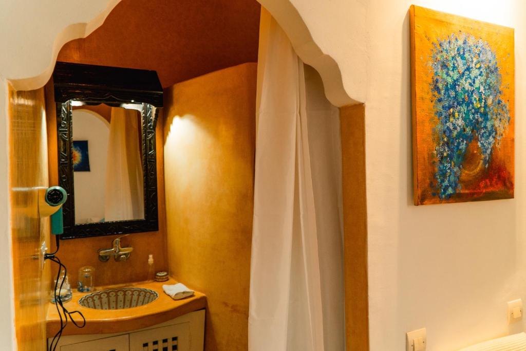 La salle de bains est pourvue d'un lavabo et d'une peinture murale. dans l'établissement Dar Liouba Hotel, à Essaouira 37 autres photos