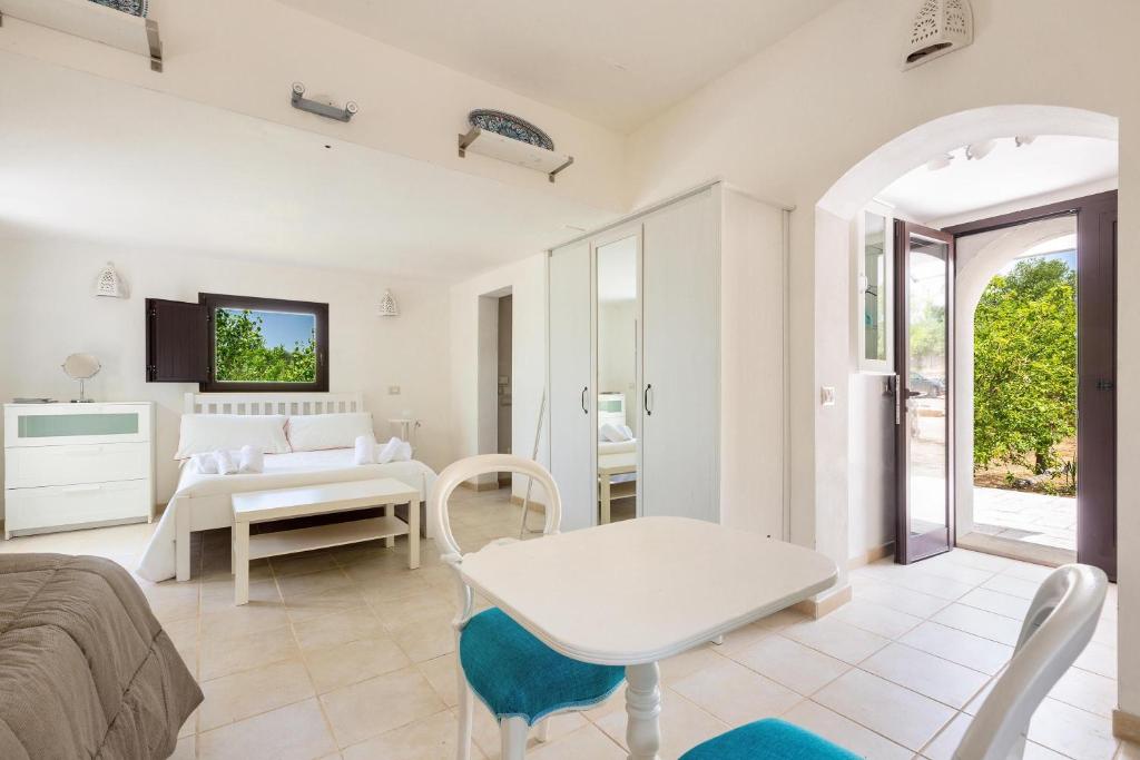 un salon avec un lit et une table dans l'établissement Villa Sessana by Perle di Puglia, à Ceglie Messapica
