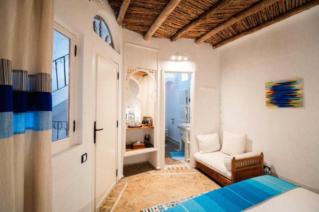 une chambre avec un lit et une chaise dans une pièce dans l'établissement Dar Liouba Hotel, à Essaouira