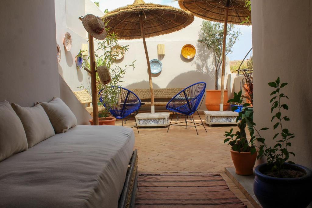 - un salon avec un canapé, des chaises et des parasols dans l'établissement Riad Amra, à Marrakech