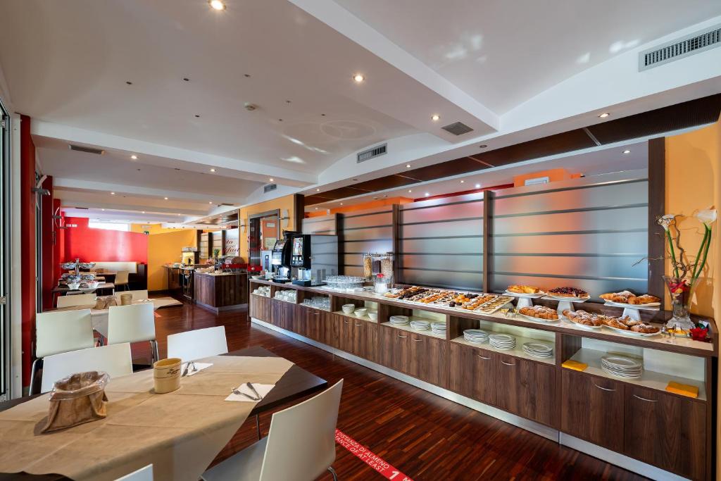 un restaurant avec un buffet de nourriture exposé dans l'établissement Hotel Sheila, à Lido di Jesolo