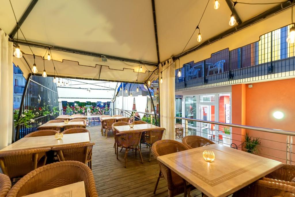 un restaurant avec des tables et des chaises sur un balcon dans l'établissement Hotel Sheila, à Lido di Jesolo