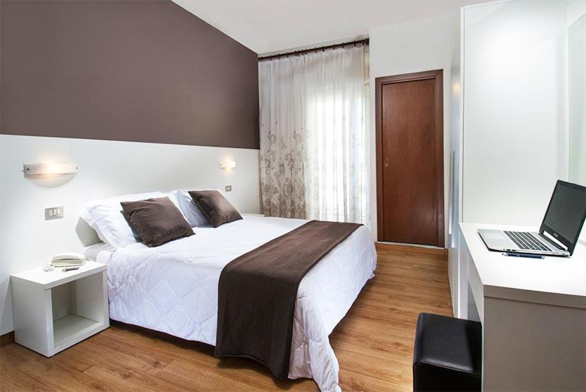 - une chambre avec un lit et un ordinateur portable sur un bureau dans l'établissement Hotel Niagara, à Cattolica