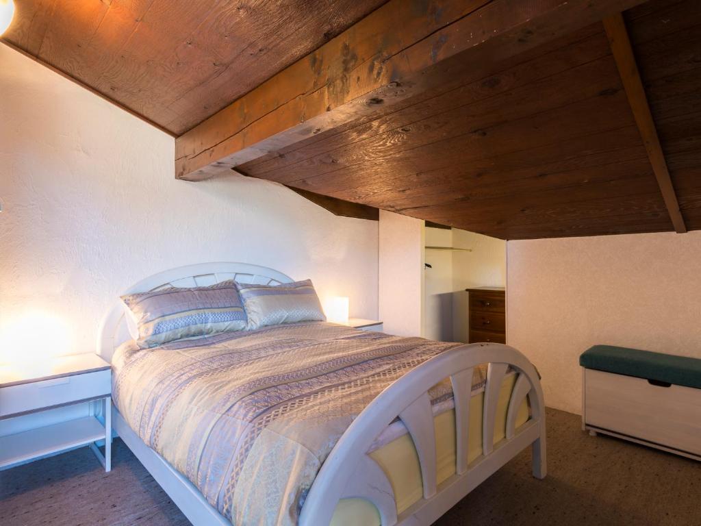 une chambre avec un grand lit avec un plafond en bois dans l'établissement Ski-in/ski-out & pool: great for summer and winter, à Saint-Gervais-les-Bains